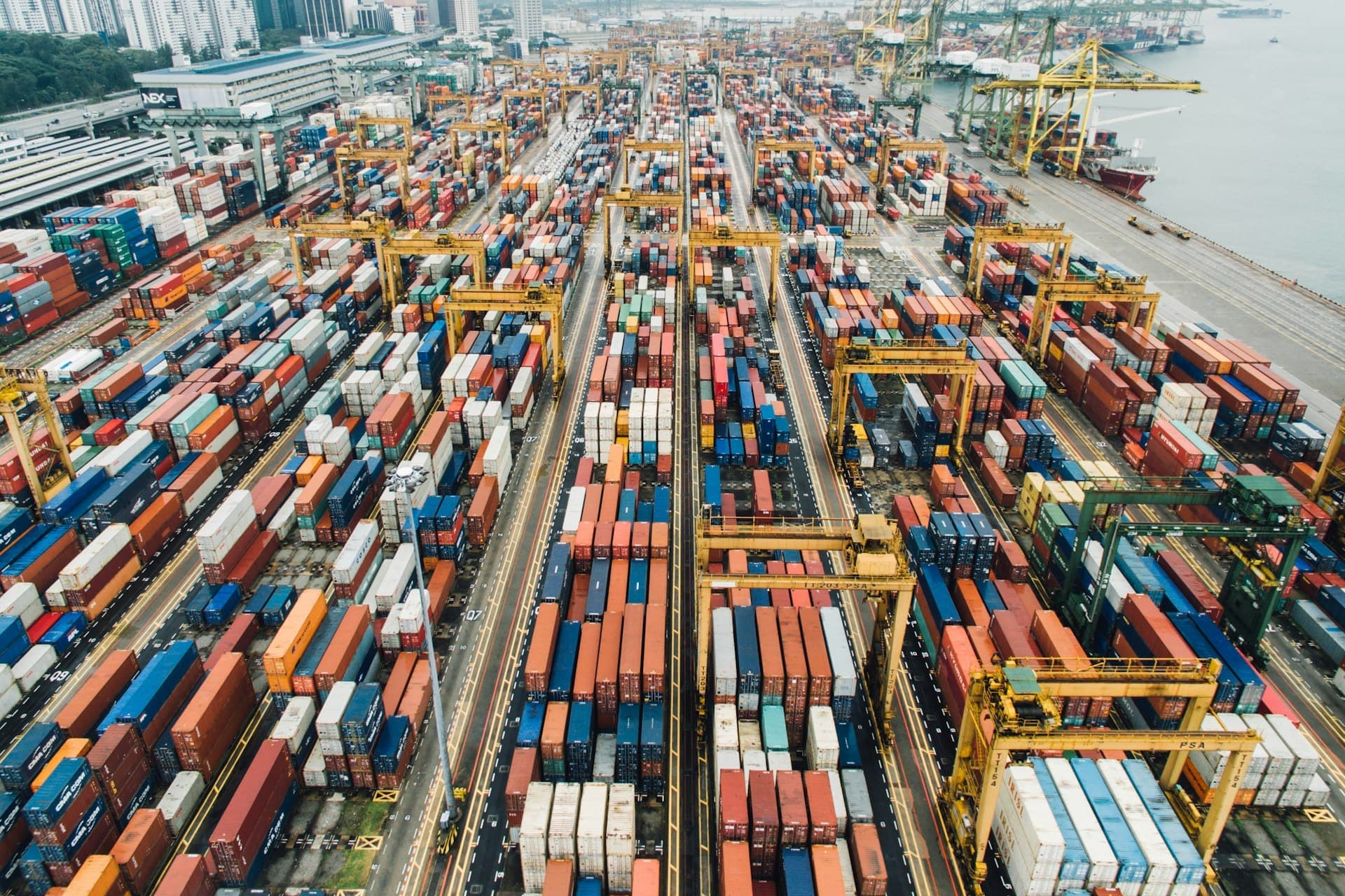 Aerial view of a container terminal with rows of stacked containers and gantry cranes