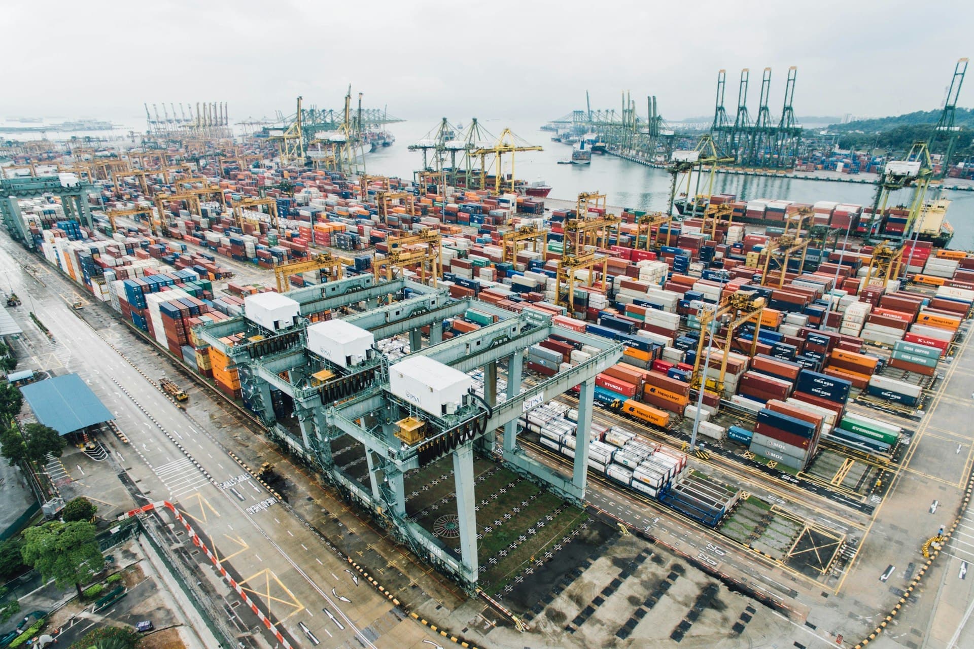 Aerial view of a busy container port with cranes and stacked containers